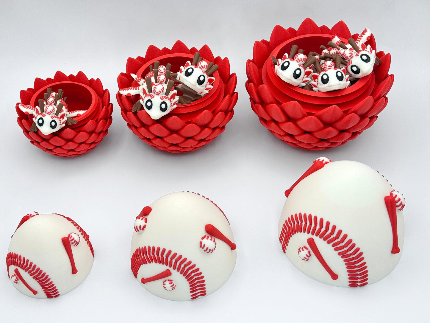 Open Baseball Dragon egg bases showing how each size holds matching baby dragons inside. Lids with baseball style red stitching are placed separately below, displaying full set contents.