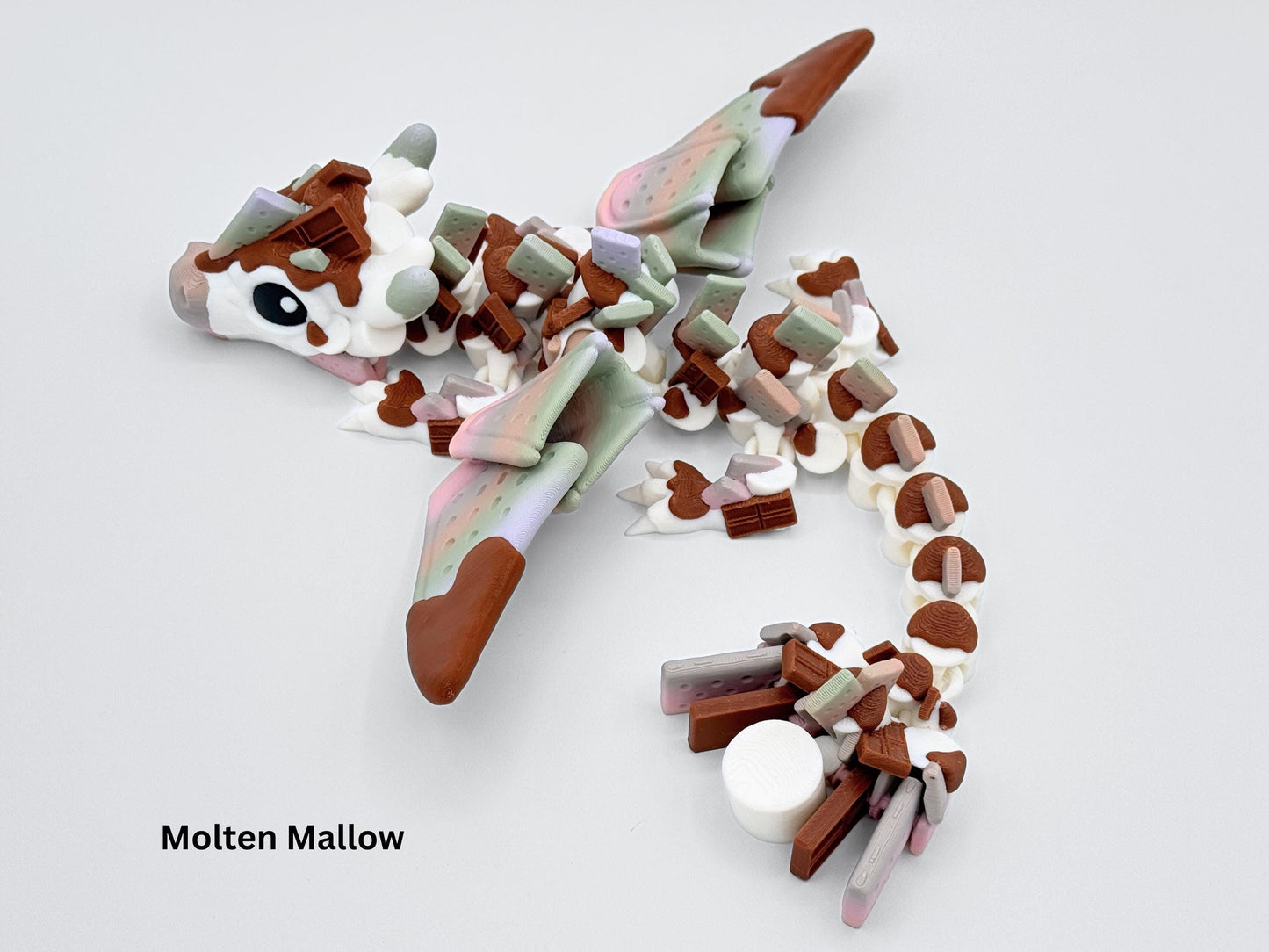 3D printed S’mores Dragon featuring a rainbow blend of marshmallow, chocolate and graham tones. This articulated 3D printed dragon fidget figurine combines dessert colors with fantasy charm and soft movement.