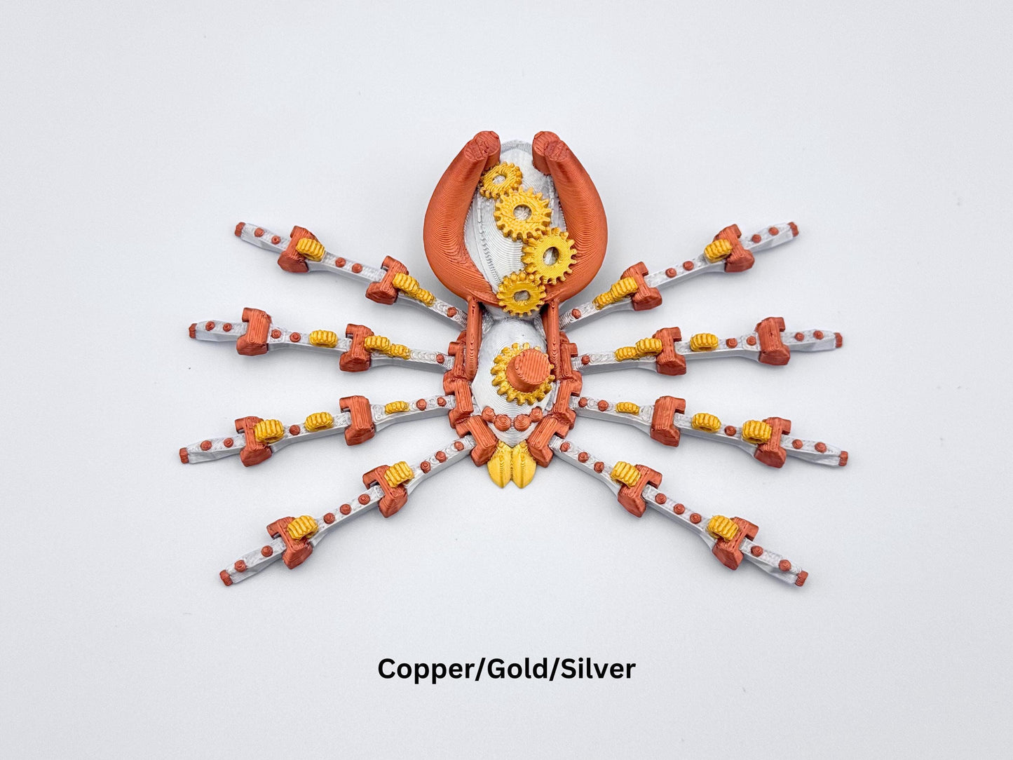 3D printed steampunk spider with eight legs and intricate mechanical gear details in copper, gold and silver colors, on a white background.