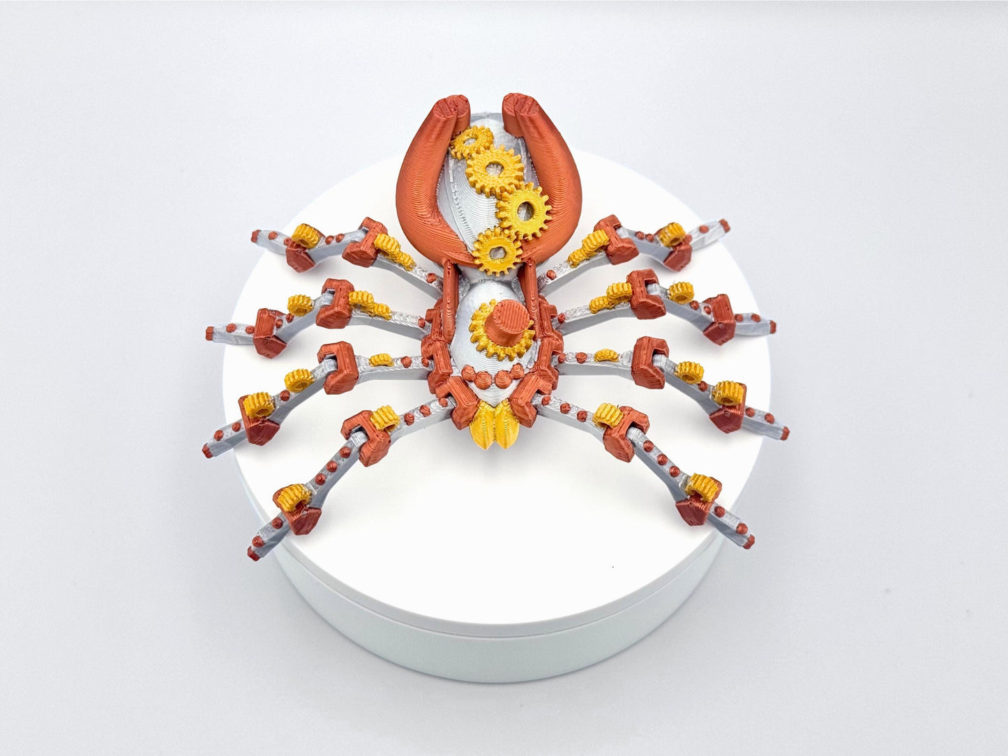 Steampunk spider 3d printed fidget in silver, coper and gold colors a mechanical spider with eight legs and a gear shaped body.