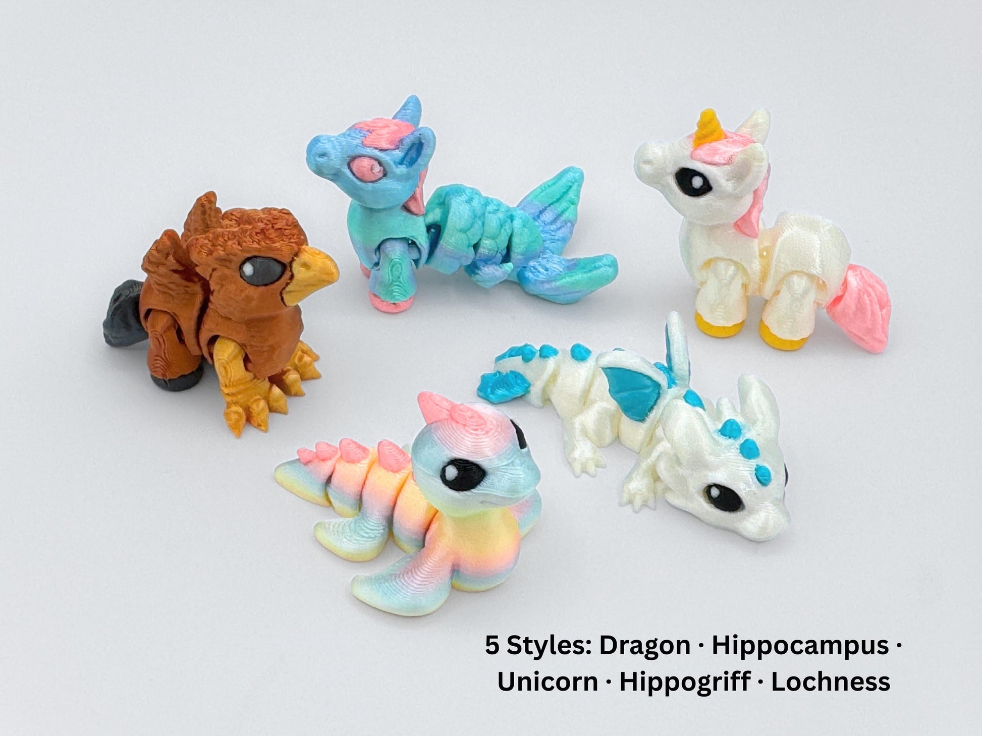 Group of five mini articulated animals — Dragon, Hippogriff, Hippocampus, Lochness and Unicorn — arranged in a circle, each in bright pastel or earth-toned color schemes.